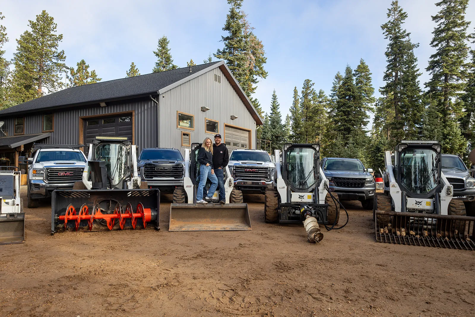Zach and Jayne Hascall with HSR vehicles and equipment at their Duck Creek Village shop